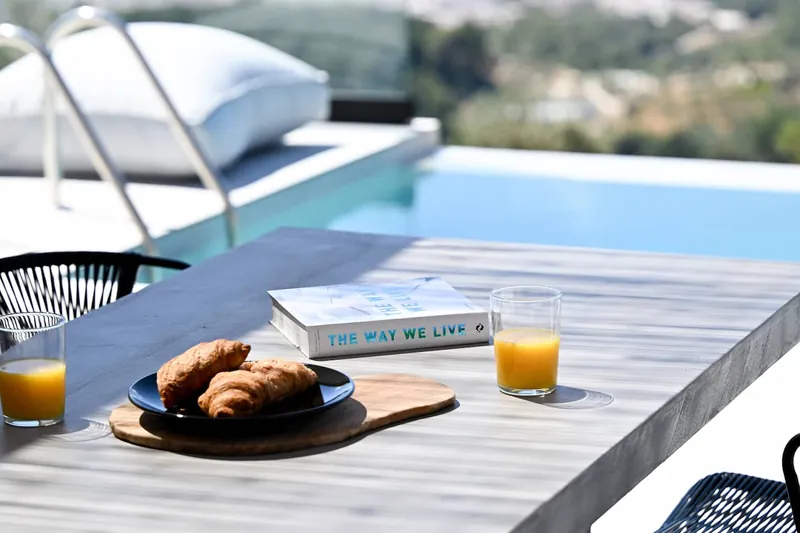 Croissants and orange juice on the terrace table by the pool