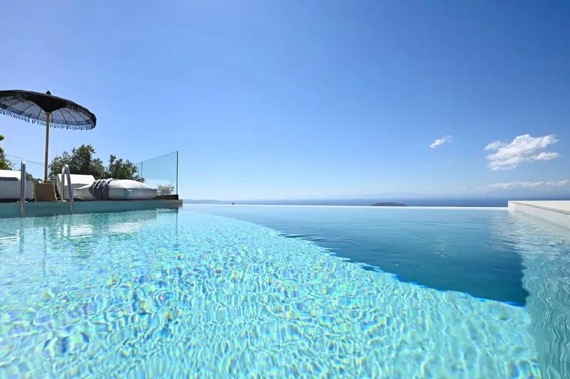 The infinity pool’s edge meeting the sea on the horizon