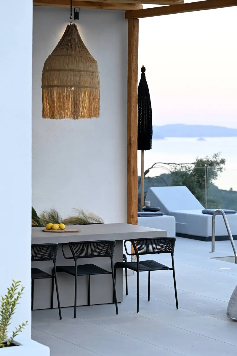 The rattan lamp and the dining table under the pergola at dusk