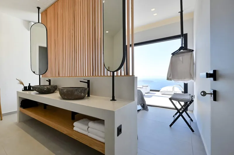 Stone washbasins on an oak shelf behind the bedroom’s slat wall